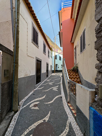 bunte Häuser entlang einer gemusterten Gasse in Paul do Mar