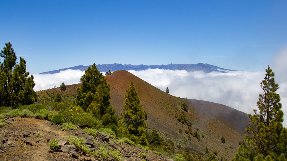die Gipfelkette der Caldera de Taburiente erhebt sich hinter dem Pico Birigoyo aus den Wolken die Gipfelkette der Caldera de Taburiente erhebt sich hinter dem Pico Birigoyo