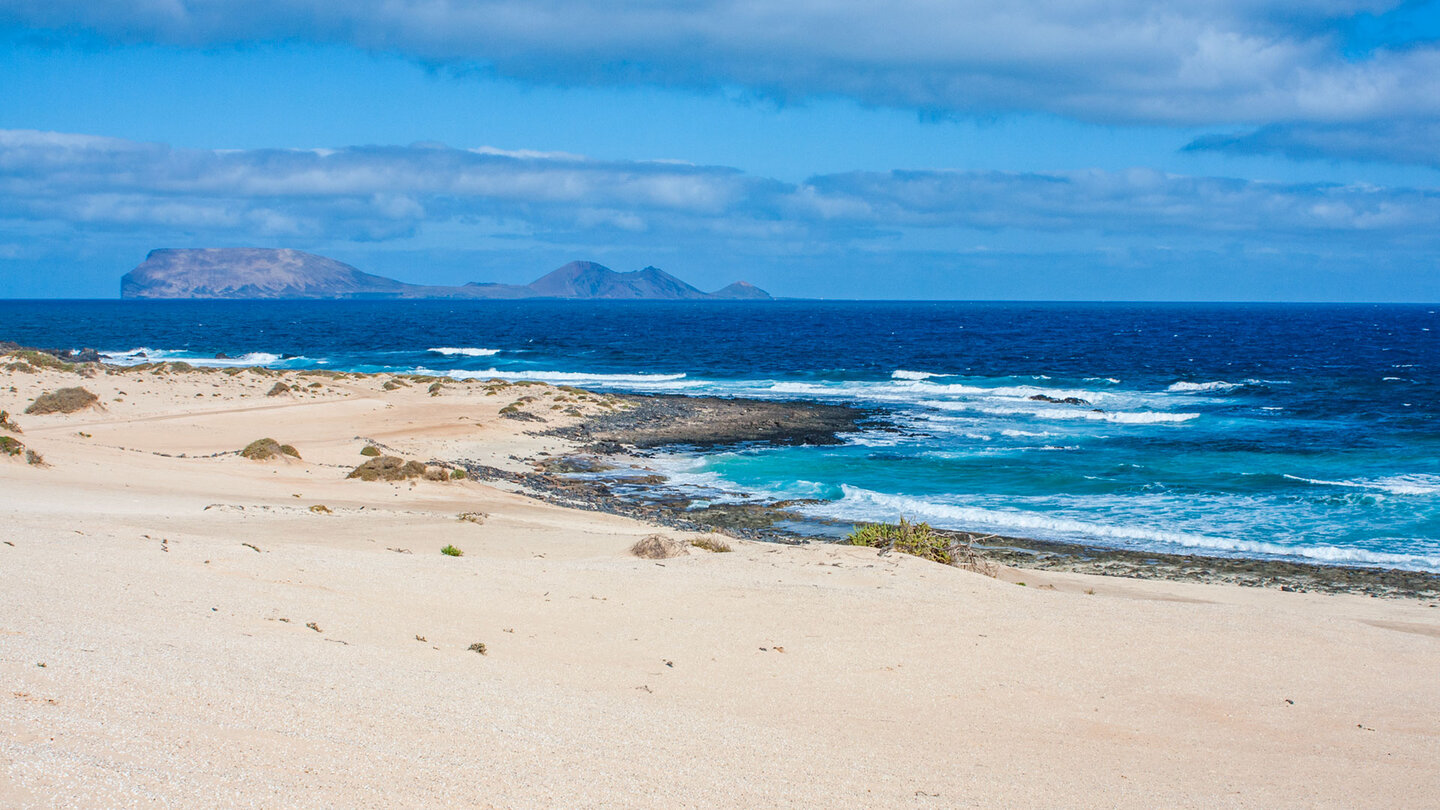 Blick über den Strand Playa del Ámbar auf die Insel Alegranza