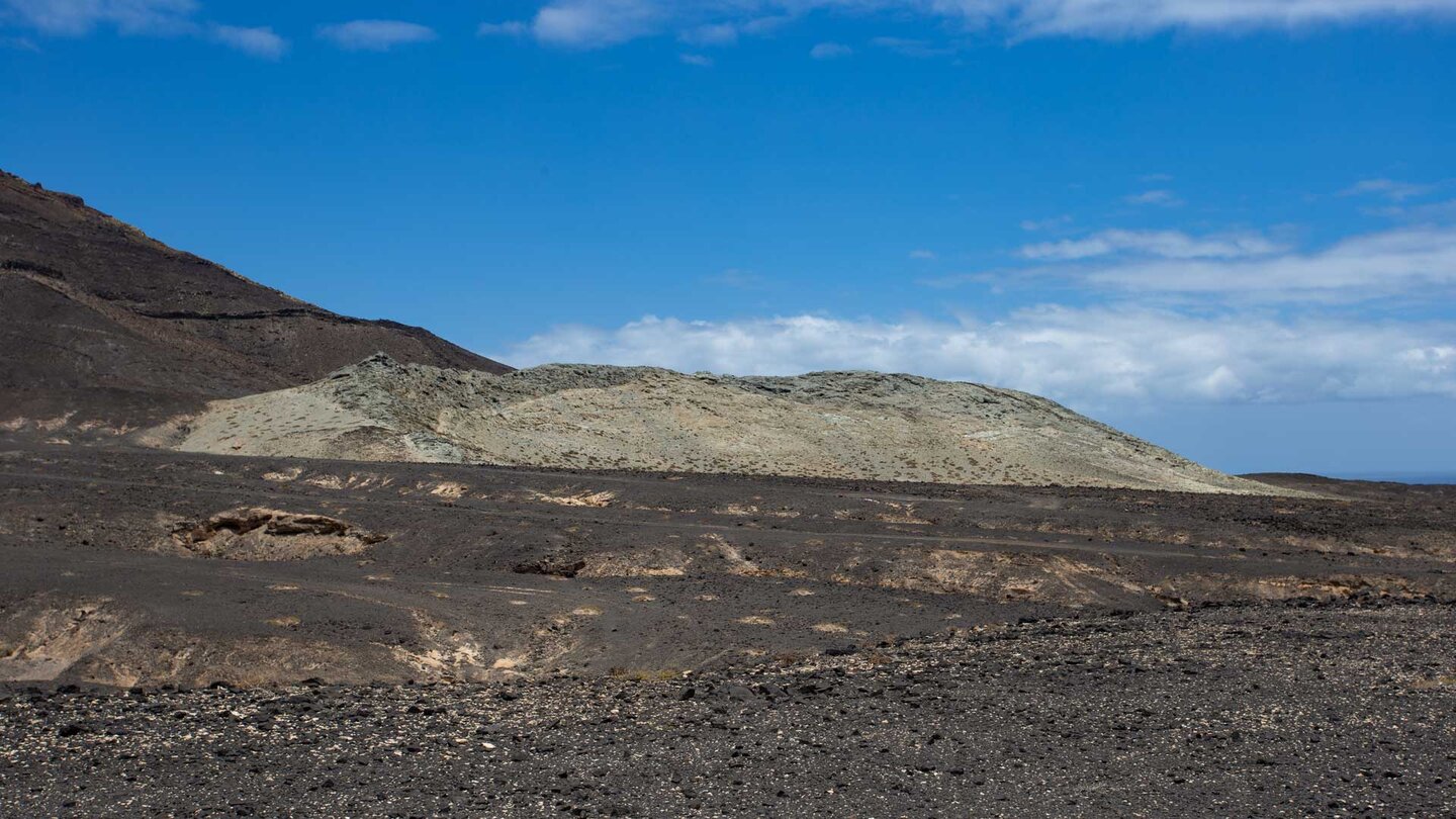 graues vulkanisches Trachyt-Gestein hebt sich aus der sonst dunklen Gebirgslandschaft ab