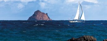 ein Segler zieht an der Insel Roque del Este im Chinijo Archipel bei Lanzarote vorbei
