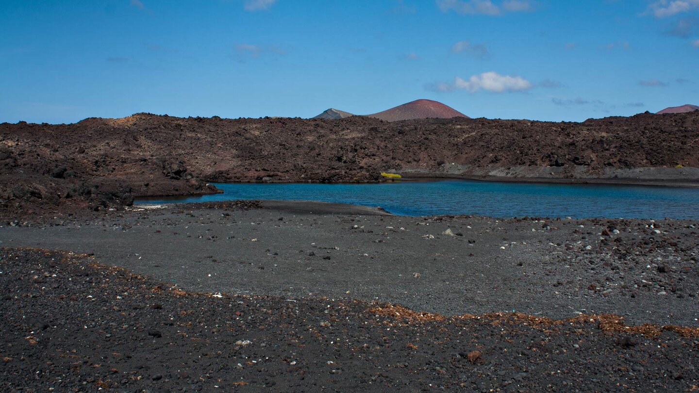 felsiges Gelände umgibt die Lagune bei der Playa de Montaña Bermeja auf Lanzarote