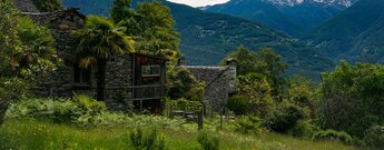 Panoramablick in Curzùtt mit Rustico und mediterraner Vegetation