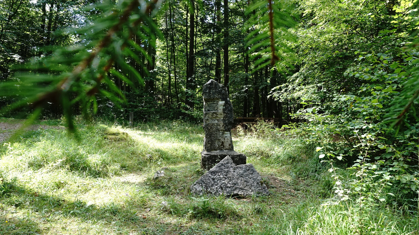 steinerner Wegweiser im Wald