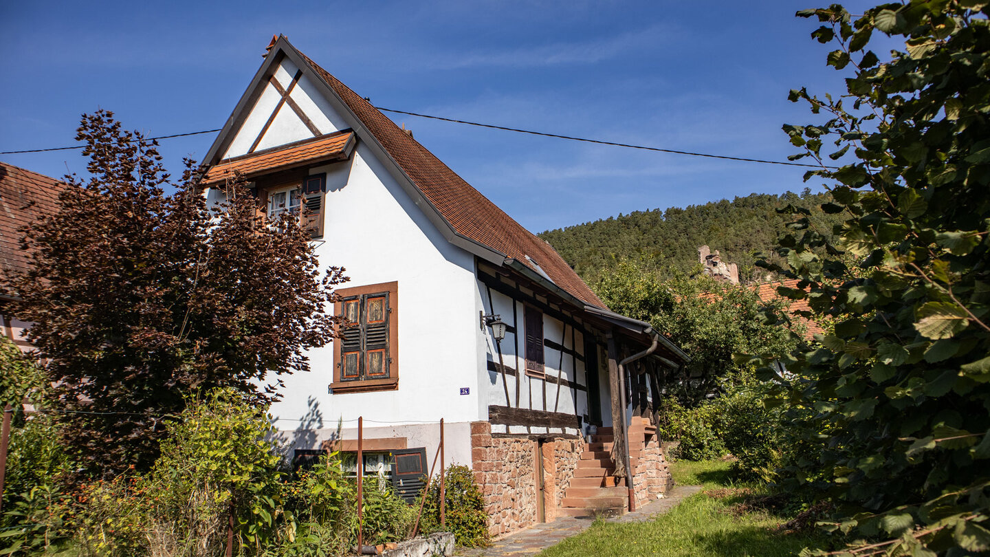 traditionelles Haus in Obersteinbach mit der Ruine Petit-Arnsberg