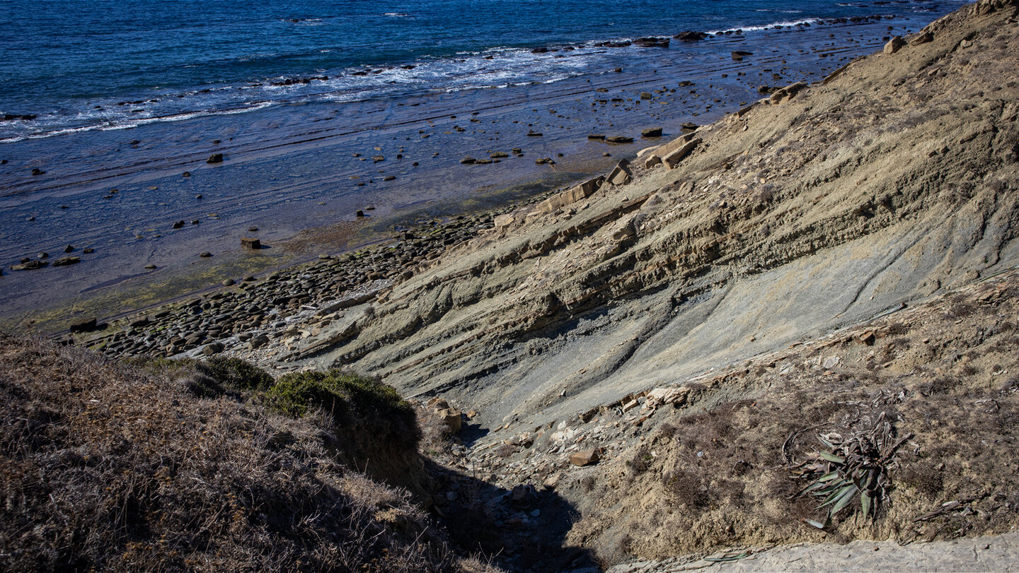 Felsformationen und kleine Schluchten führen zum Gezeitenstrand