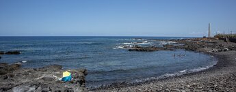 felsige Strände bei Punta del Hidalgo auf Teneriffa mit dem Leuchtturm im Hintergrund