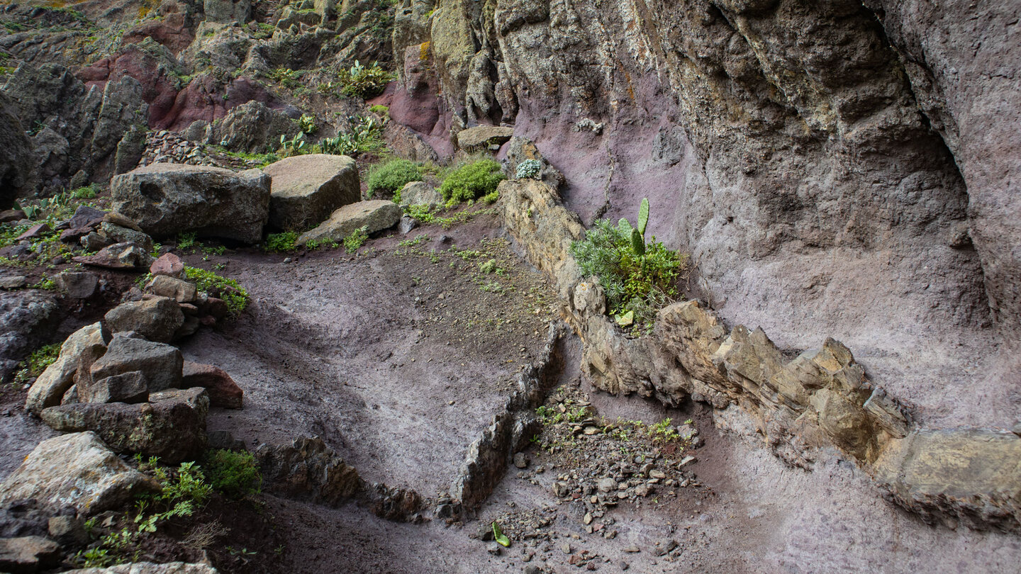 Wegabschnitt des Camino del Risco durch rötliche Gesteinsformationen