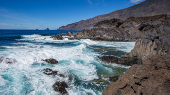 Ausblick über die Basaltklippen am Meerwasserbad Charco de Los Sargos auf die Roques de Salmor