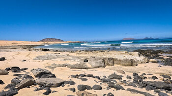 Montaña Clara und Alegranza vom Strand Playa del Ámbar