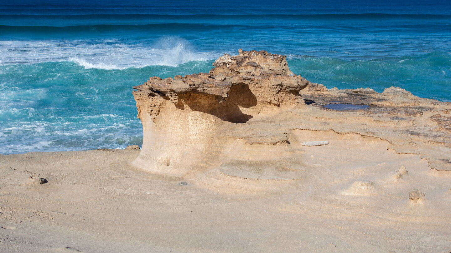 Sandsteinskulptur vor der Brandung der Wellen Sandsteinskulptur vor der Brandung der Wellen
