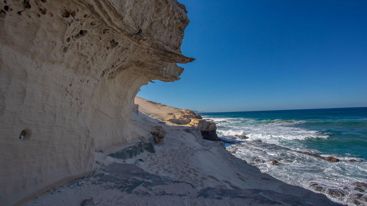 Wanderpfad unterhalb einer imposanten Sandsteinwand