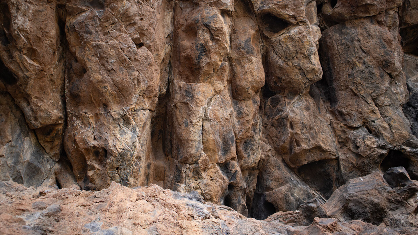 erodiertes Gestein in den steilen Felswänden entlang des Wanderwegs
