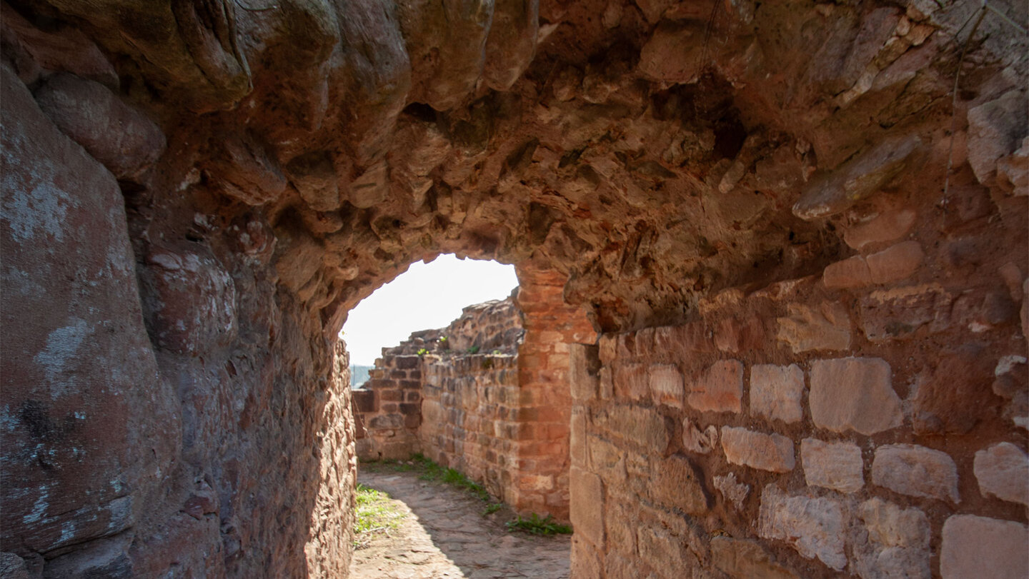 Ein Rundgang führt durch die verschiedenen Ebenen der Ruine Drachenfels, vorbei an Mauerresten, dem Bergfried und den in den Fels gehauenen Wegen.