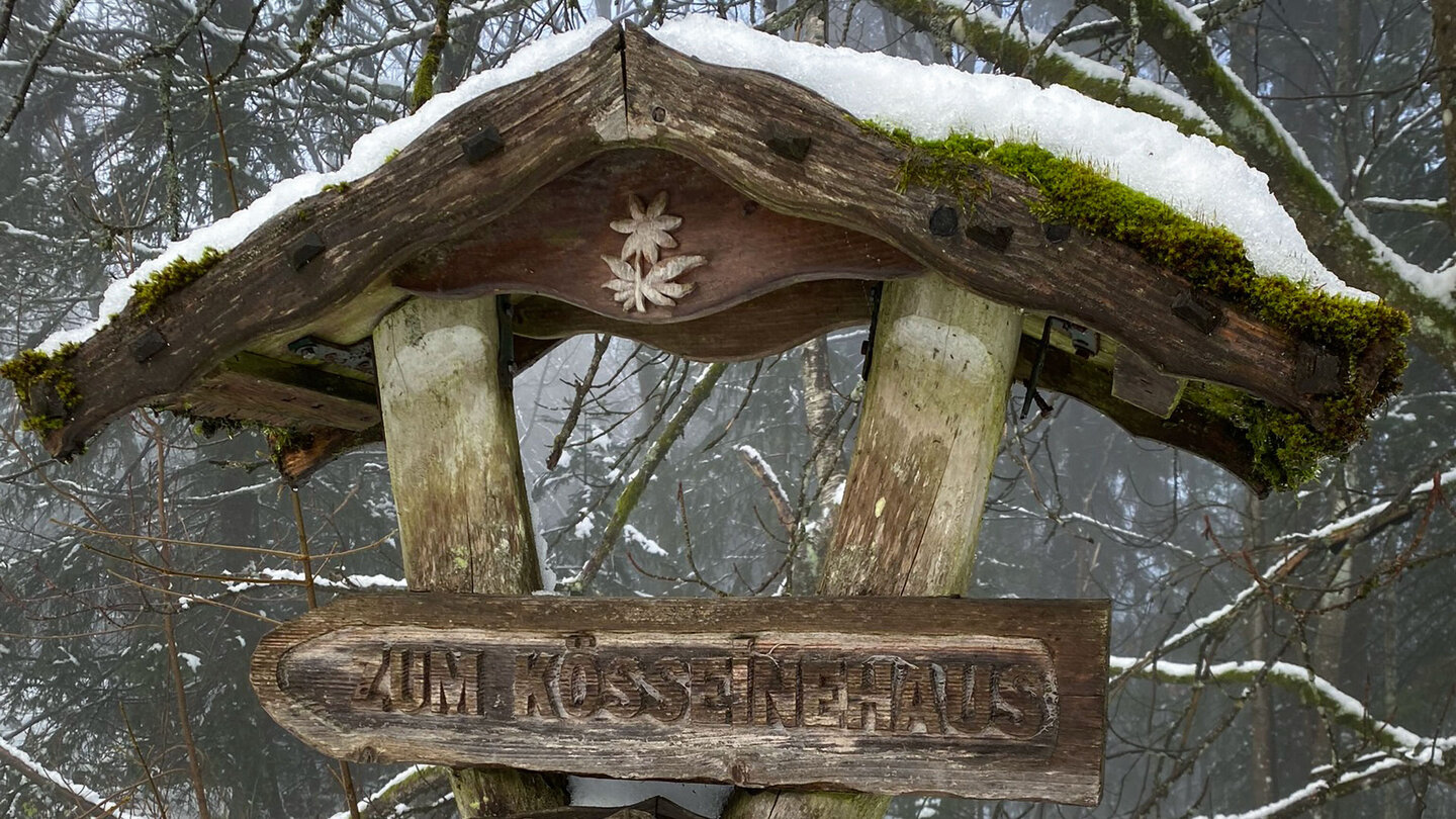 ein Holzschild weist den Weg zum Kösseinehaus