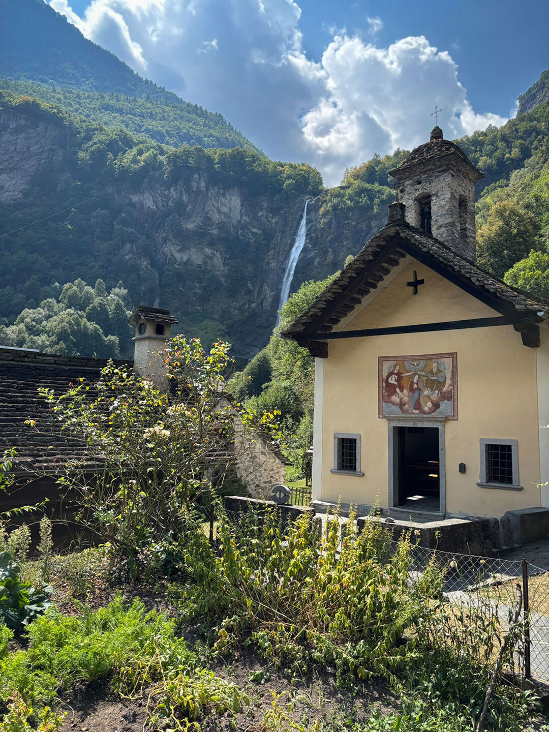 die Kirche aus dem 15. Jahrhundert und der Wasserfall im Hintergrund in Foroglio