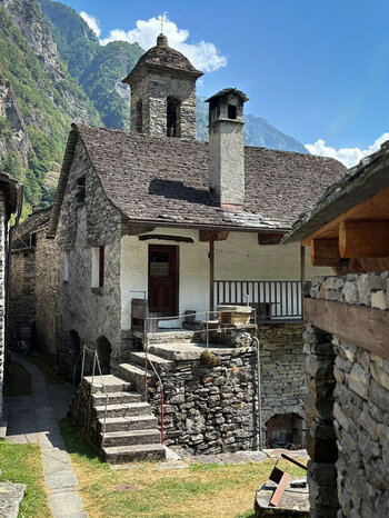 Steinhäuser mit der Kirche im Hintergrund in Foroglio