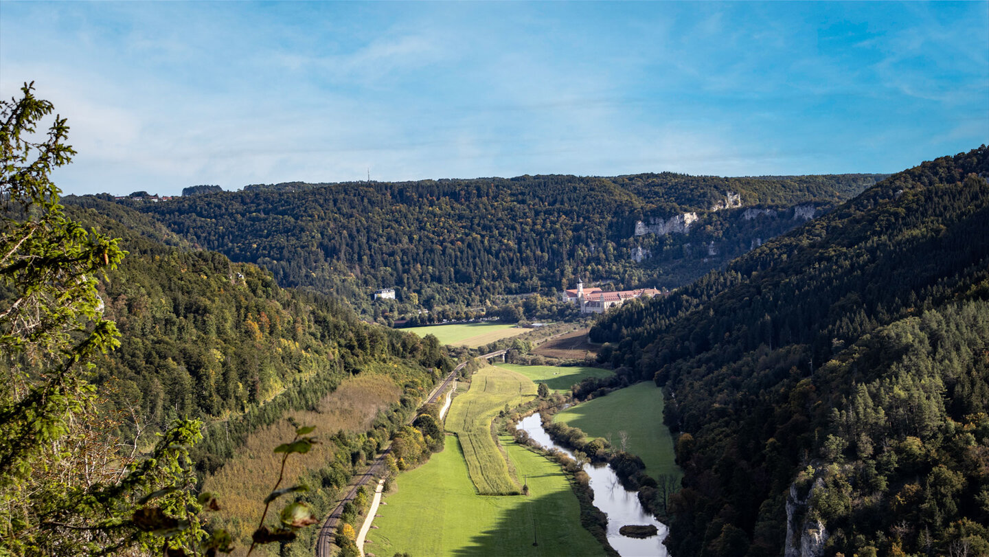 Blick vom Knopfmacherfelsen über das Donautal auf die Erzabtei Beuron mit Klosterkirche und umliegenden Wiesen