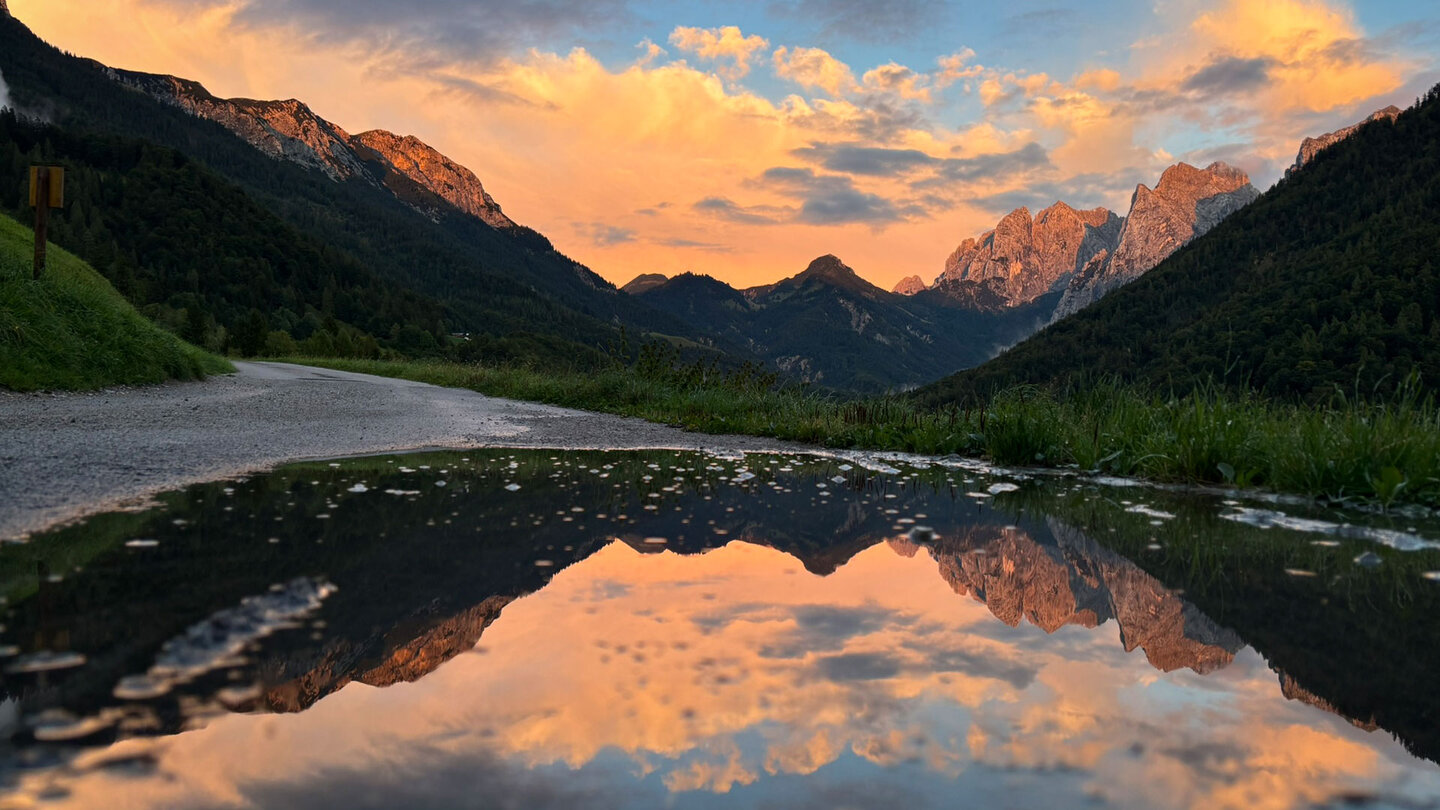 Zahmer und Wilder Kaiser spiegeln sich in der Pfütze im Abendrot