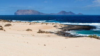 die Insel Alegranza hinter dem Strand Playa del Ámbar