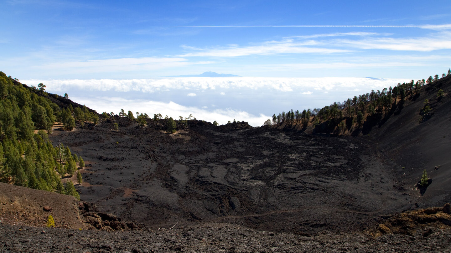 der pechschwarze Lavasee Lavas la Malforada mit Teneriffa am Horizont