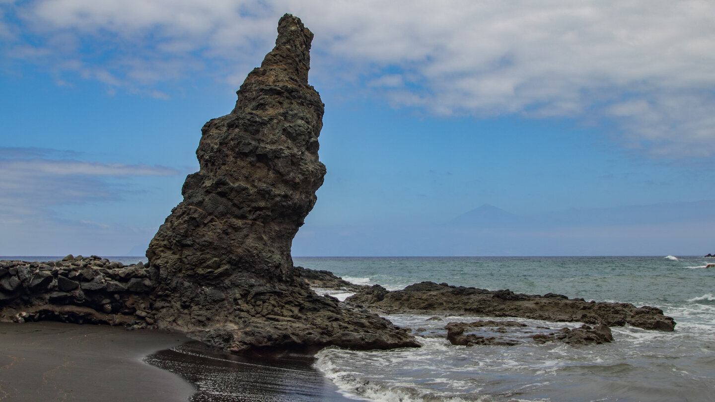Felsnadel am Strand von Playa de la Caleta auf La Gomera mit dem Teide auf Teneriffa im Hintergrund Felsnadel am Strand von Playa de la Caleta mit dem Teide auf Teneriffa im Hintergrund