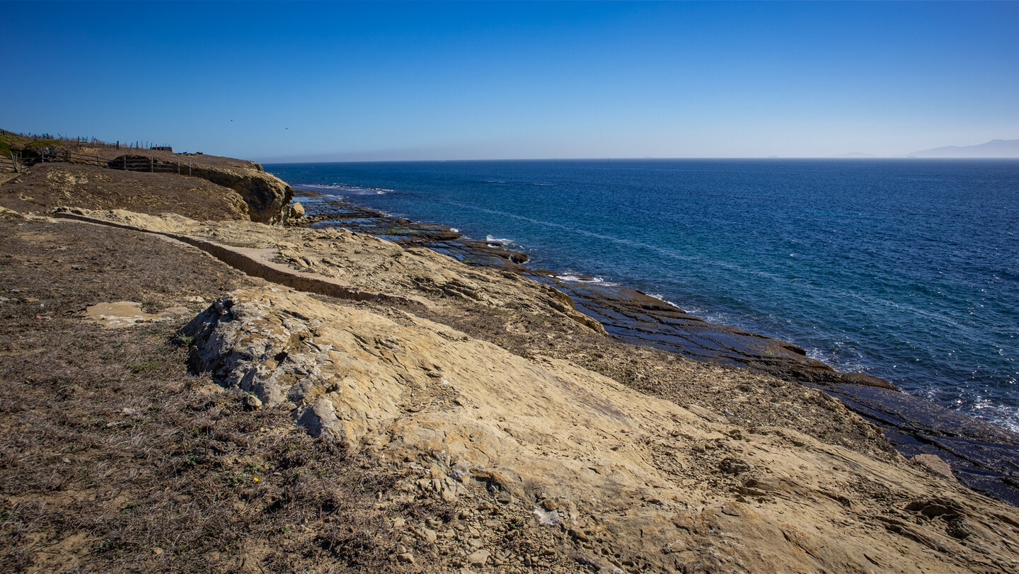 Entlang der Route säumen Weiden und erodierte Felsen den Wanderpfad