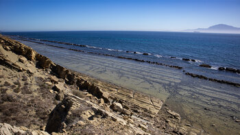 Gezeitenstrand am „Colada del Camino” mit Schichtgestein und Linien im Fels des Flysch del Estrecho