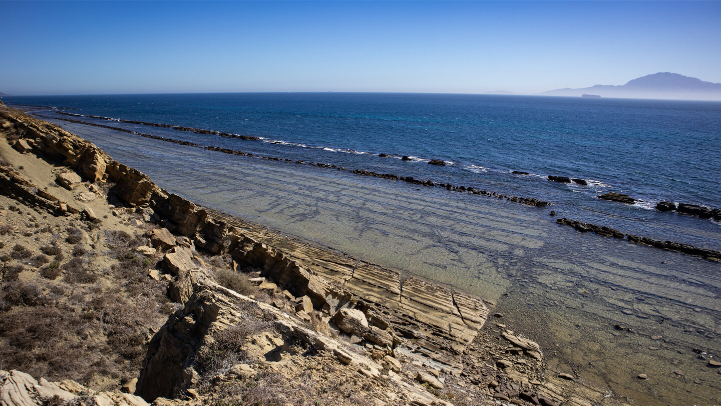 Gezeitenstrand am „Colada del Camino” mit Schichtgestein und Linien im Fels des Flysch del Estrecho