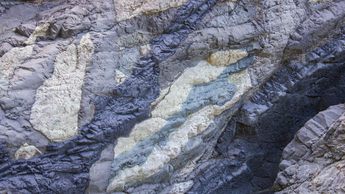 das Farbenspiel verschiedener Gesteinsarten in den Felswänden der Schlucht Farbenspiel in den Felswänden