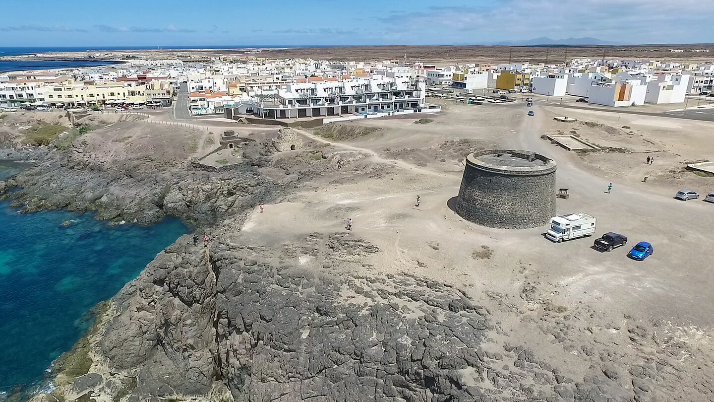 der Turm des Castillo de El Tostón mit dem Ort El Cotillo auf Fuerteventura im Hintergrund